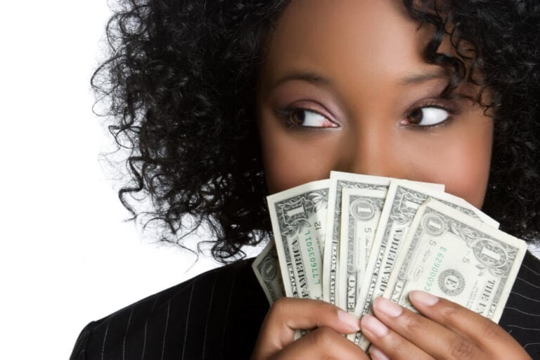 woman fanning money in front of face